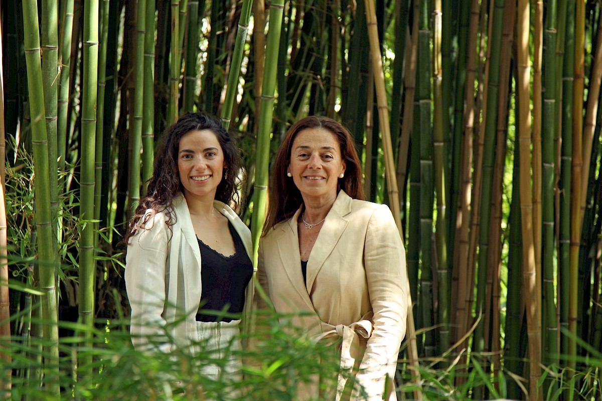 Tres mujeres sonrientes en el césped de un parque